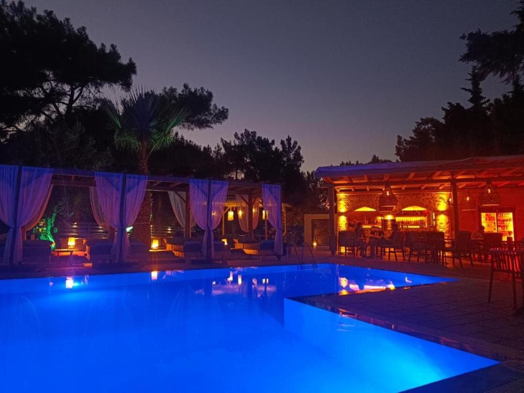The infinity pool at night, lit blue beside the pool bar